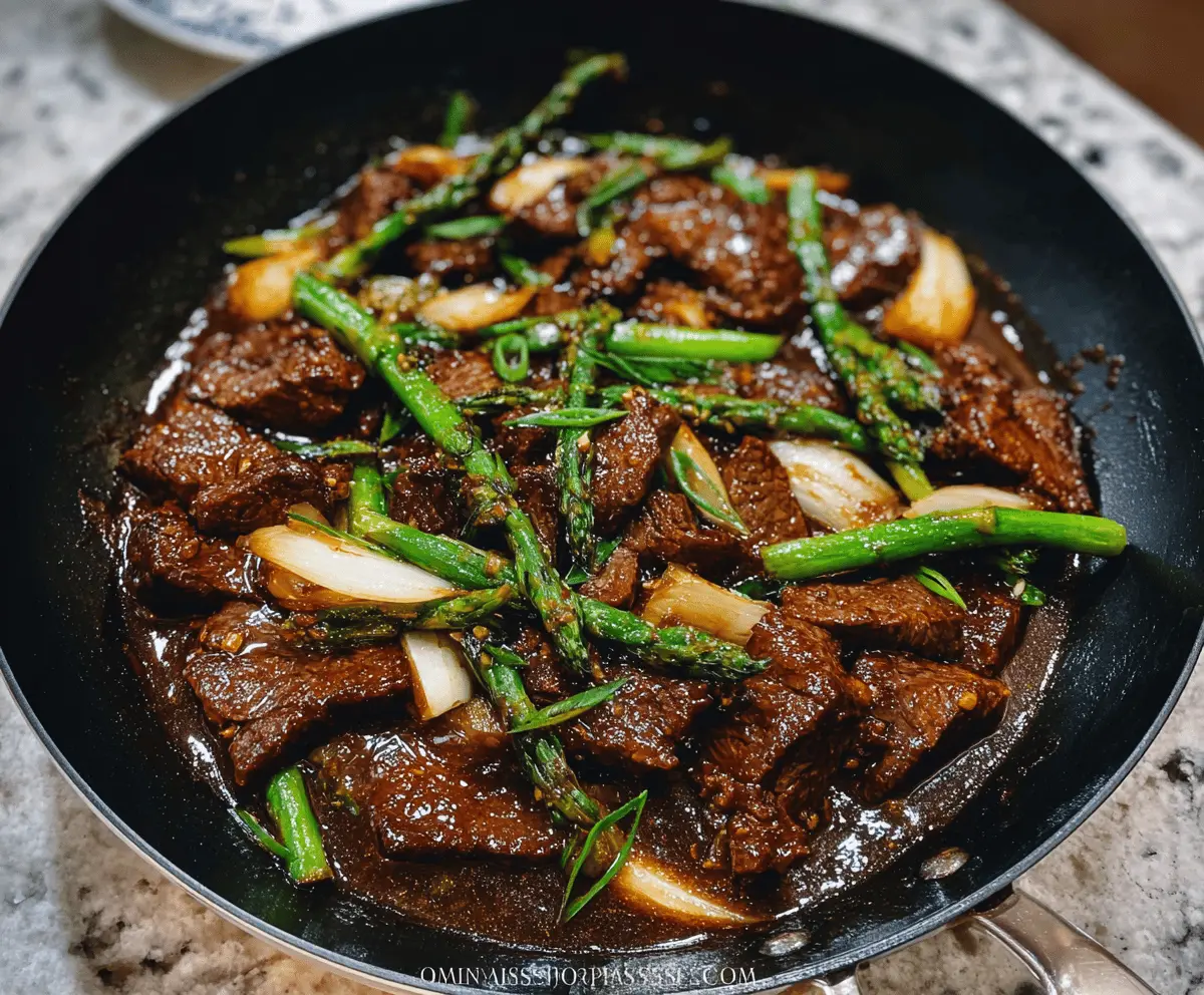 Delicious savory beef stir-fry cooked with rich oyster sauce, garnished with fresh green onions on a white plate.