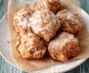 Delicious warm baked apple fritters topped with cinnamon sugar, served on a plate for a perfect fall dessert