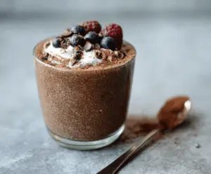 Creamy mocha chia pudding topped with whipped cream and cocoa powder, served in a glass jar for a delicious and healthy breakfast or snack.