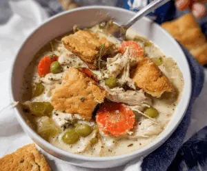 Creamy keto chicken pot pie soup in a slow cooker with vegetables and herbs, perfect for low-carb comfort meals