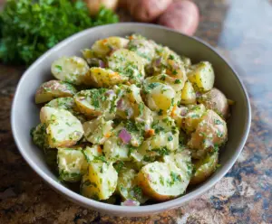 Delicious French style potato salad with fresh herbs and creamy dressing on a rustic plate.