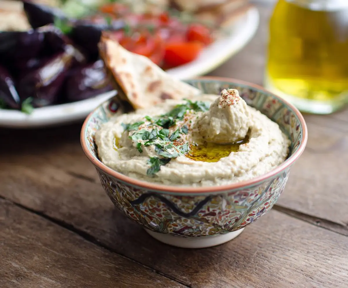 Creamy Baba Ganoush roasted eggplant dip served with fresh pita bread and vegetables.