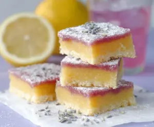 Delicious Lavender Lemon Bars on a white plate with fresh lavender and lemon slices